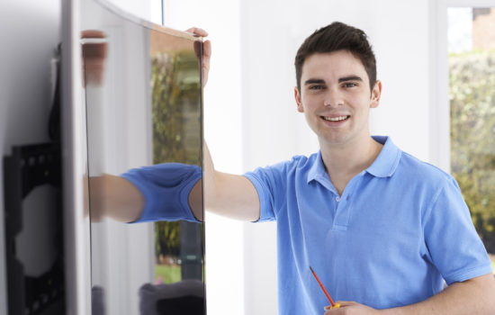 57482725 - engineer fitting curved screen television in home 57482725 - engineer fitting curved screen television in home